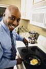 man cooking eggs on a skillet