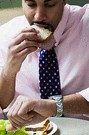 african american man eating a sandwich