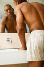 african american man in boxers looking into mirror