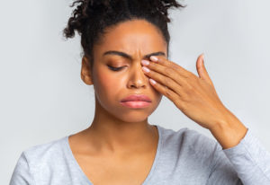 Woman rubbing swollen eyes.