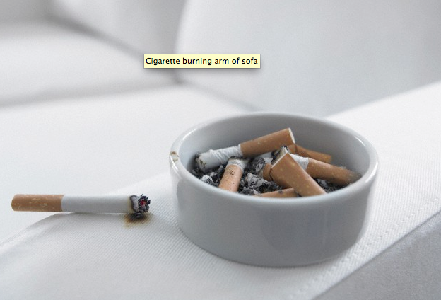 Cigarettes sitting in a white ashtray on a white sofa