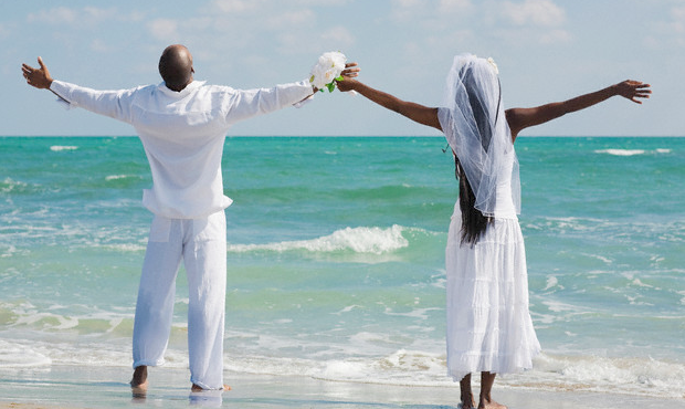 black groom and bride at beach
