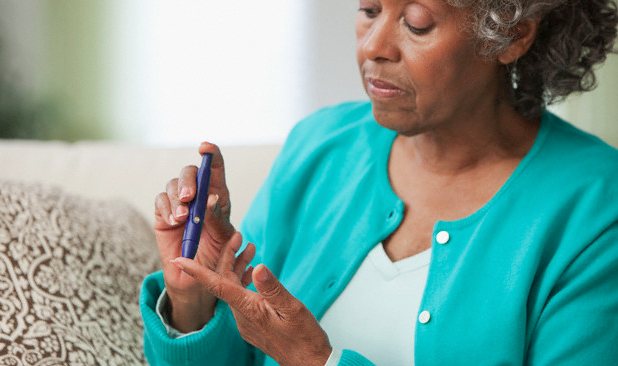 A diabetic woman using a blood sugar monitor on her finger