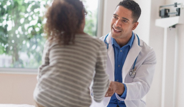A smiling doctor having a conversation with a little girl