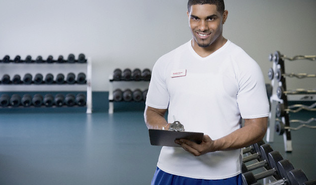 A smiling personal trainer with a clipboard