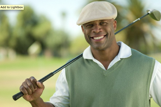 A smiling man wearing a golf hat and holding a golf club