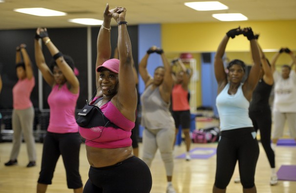 overweight fitness instructor leading a group in workout