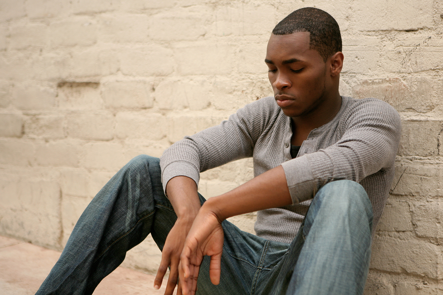 young african american man sitting with head