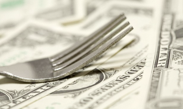 Dollar bills with a fork sitting on top