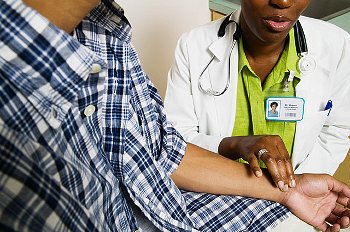 A doctor taking a teenager's pulse