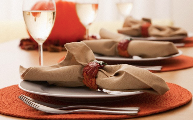 A dining table set with fall decorations