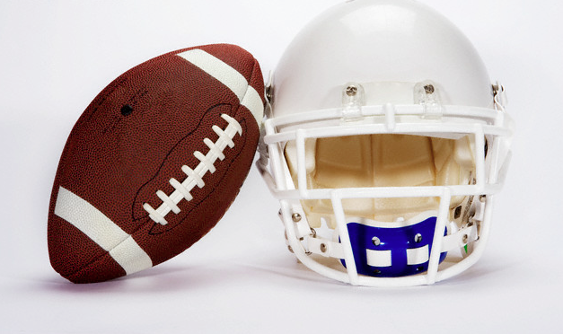 A football sitting next to a helmet