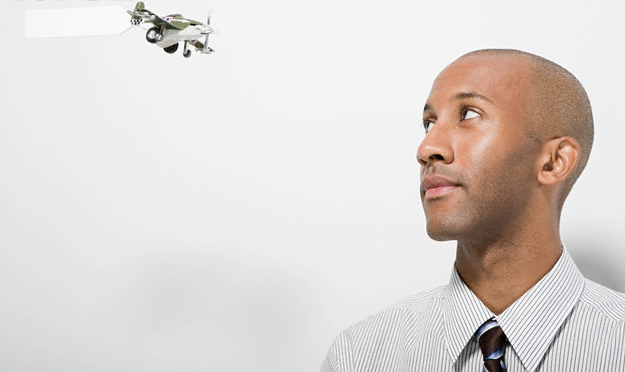 A man looking at a toy plane