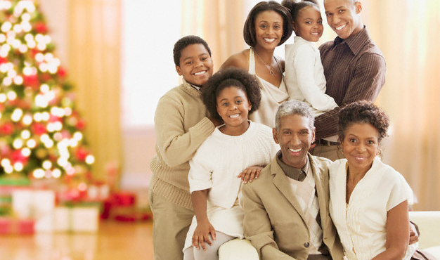 A multi-generational family posing near a Christmas tree