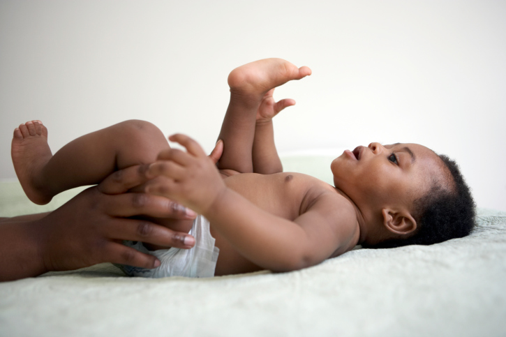 baby lying down looking at his toes
