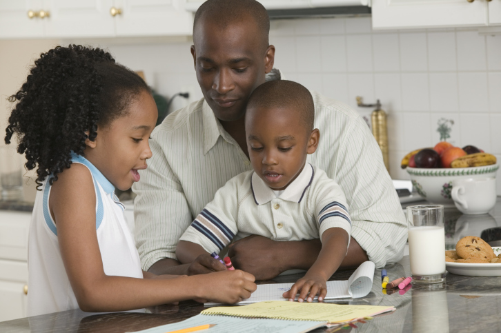 father coloring with son and daughter