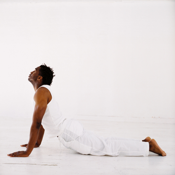 side profile of a man doing stretching exercises on the floor