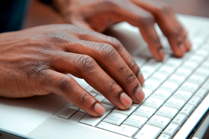 Close up of black hands on a keyboard
