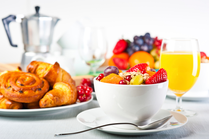 bowl of fruit, toast, juice and cereal