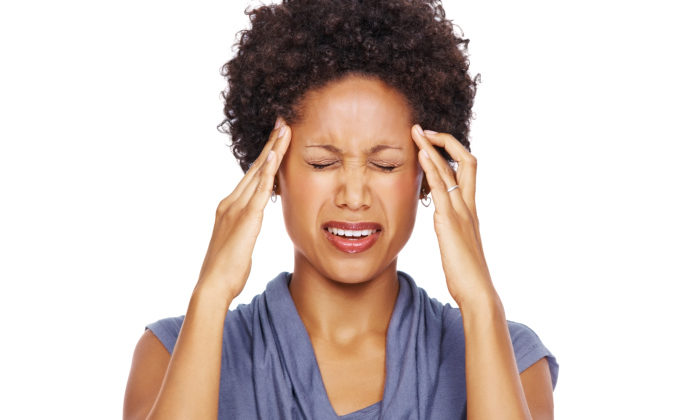 woman with headache, holding temples