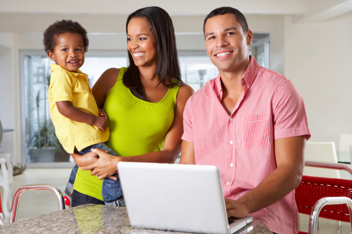 family in kitchen laptop