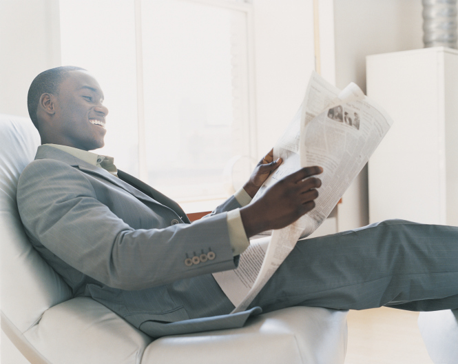 Businessman Relaxing in an Armchair in a Hotel Room