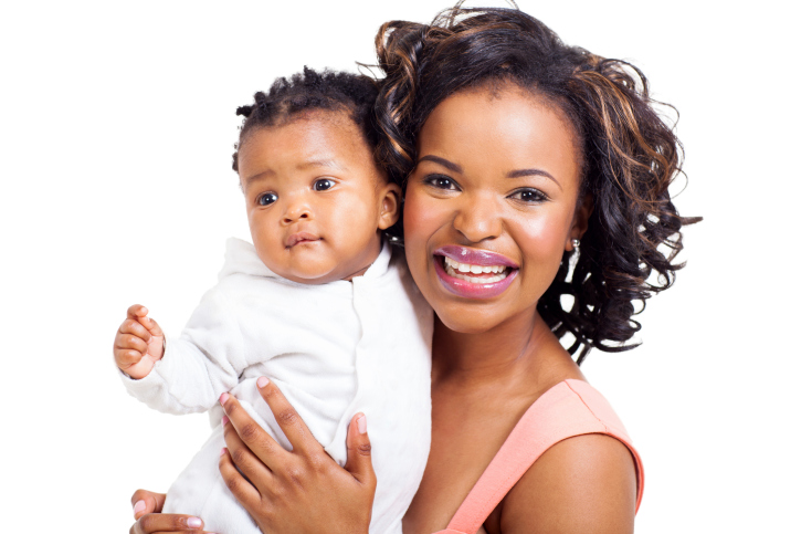 mother holding baby girl smiling