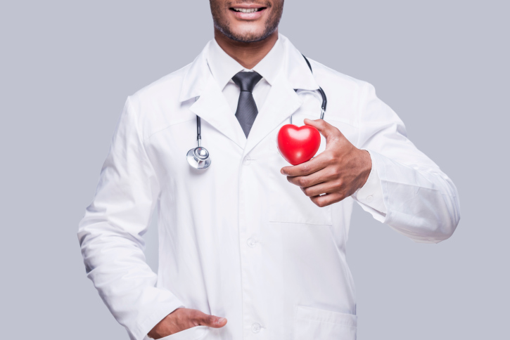 smiling doctor holding a red heart