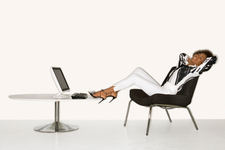 Reclining woman with feet up by computer