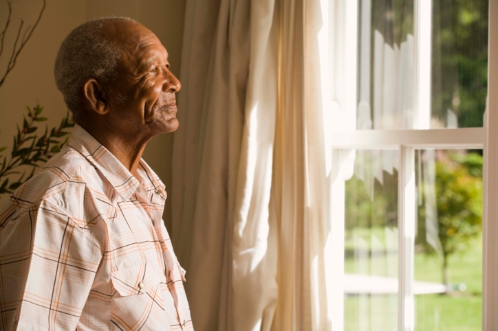 older man looking out window