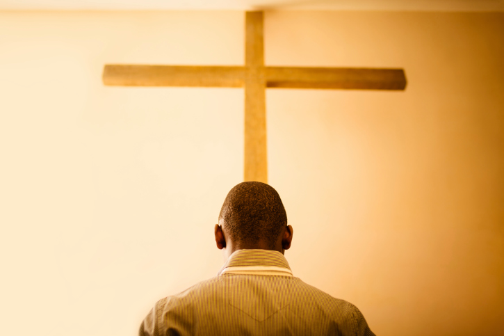 man in front of cross