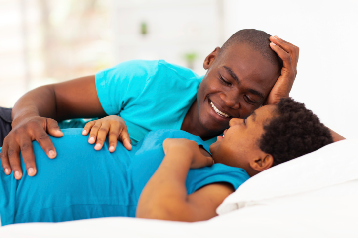 pregnant couple in bed