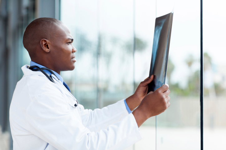 black doctor looking at xray