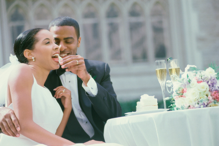 Groom feeding bride cake