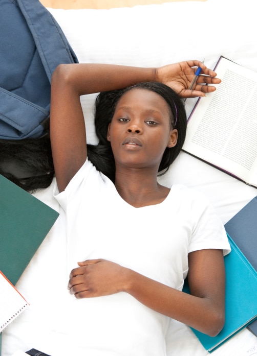 teen girl on floor surrounded by books