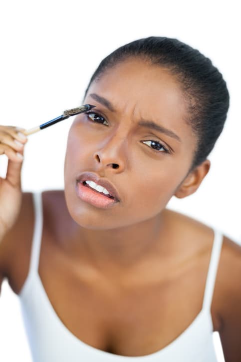 woman putting on mascara
