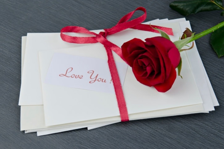 love letter wrapped in red ribbon with rose