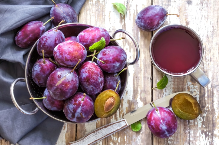 Bowl of plums cup of plum juice