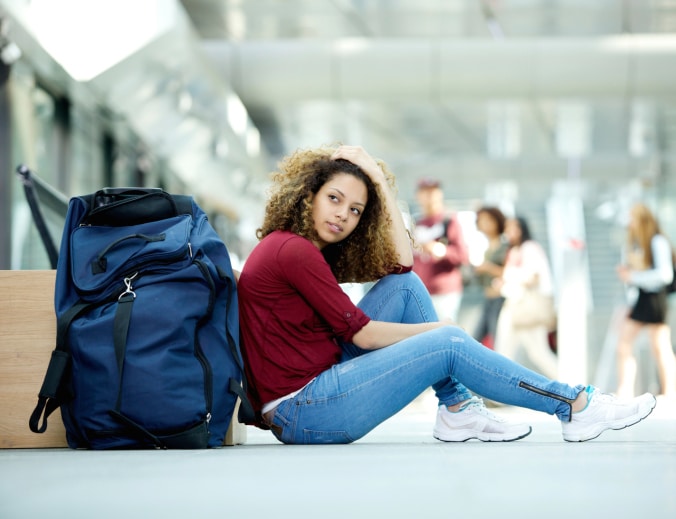 young African American woman sitting air airport duffle bag