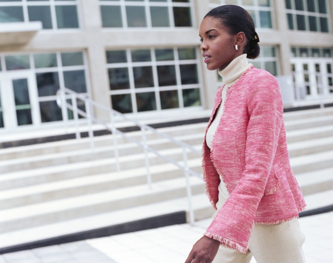 African American Black Businesswoman walking by office building, side view