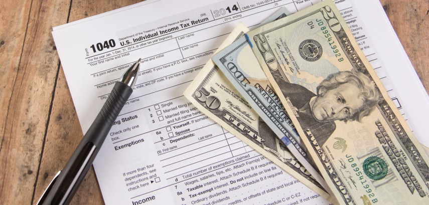 1040 tax form with calculator and dollar bills