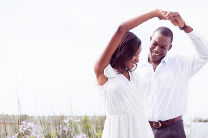 African American happy couple dancing outside