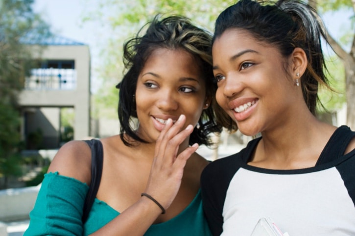 Two African American teen girls gossiping