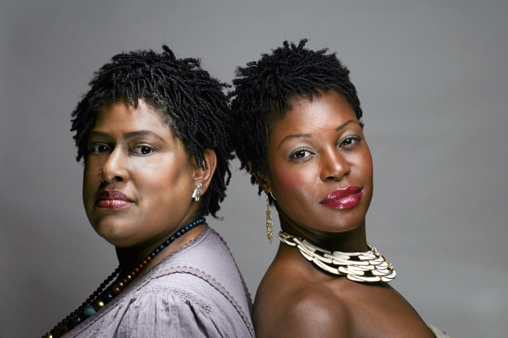 two black women standing back to back