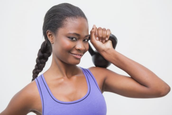 African American woman lifting small kettlebell
