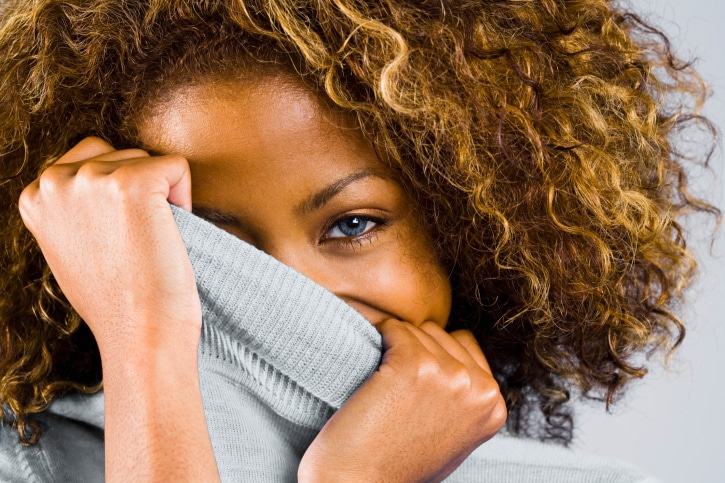 African American woman curly hair covering face