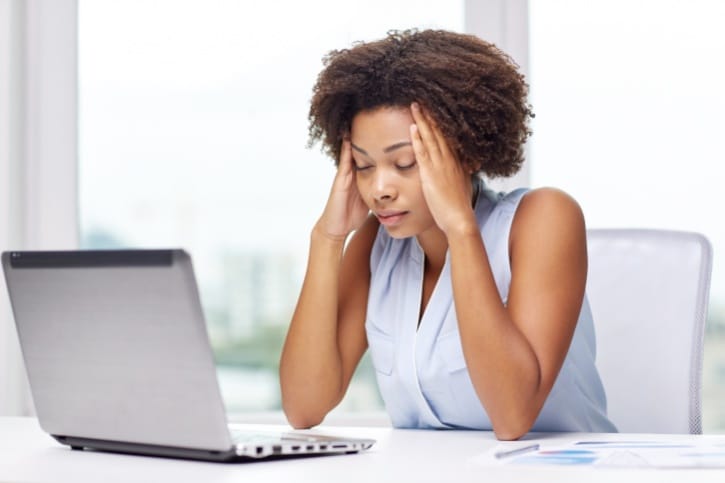 African American woman with headache on laptop