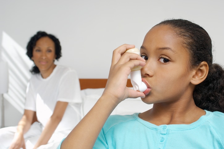 African American girl with asthma inhaler