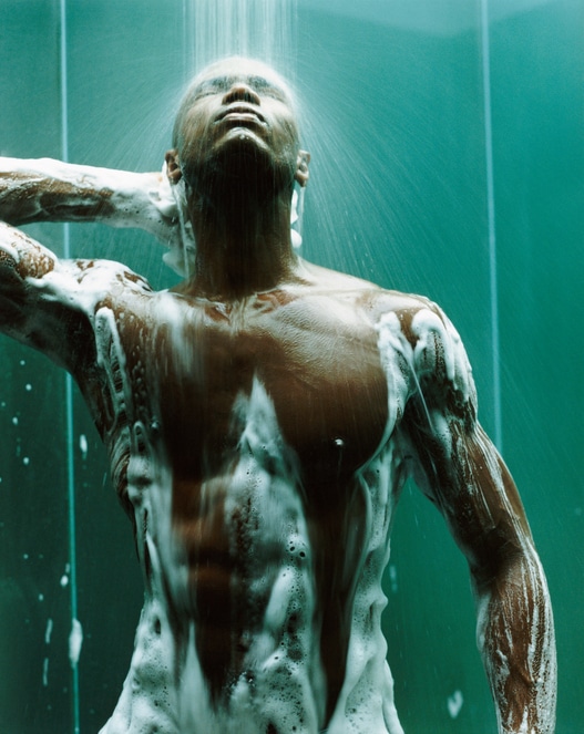 Young, Muscular Man Stands in the Shower, Covered in Soap Suds