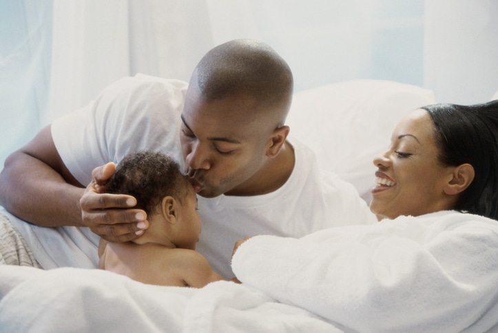 African American family in bed with baby